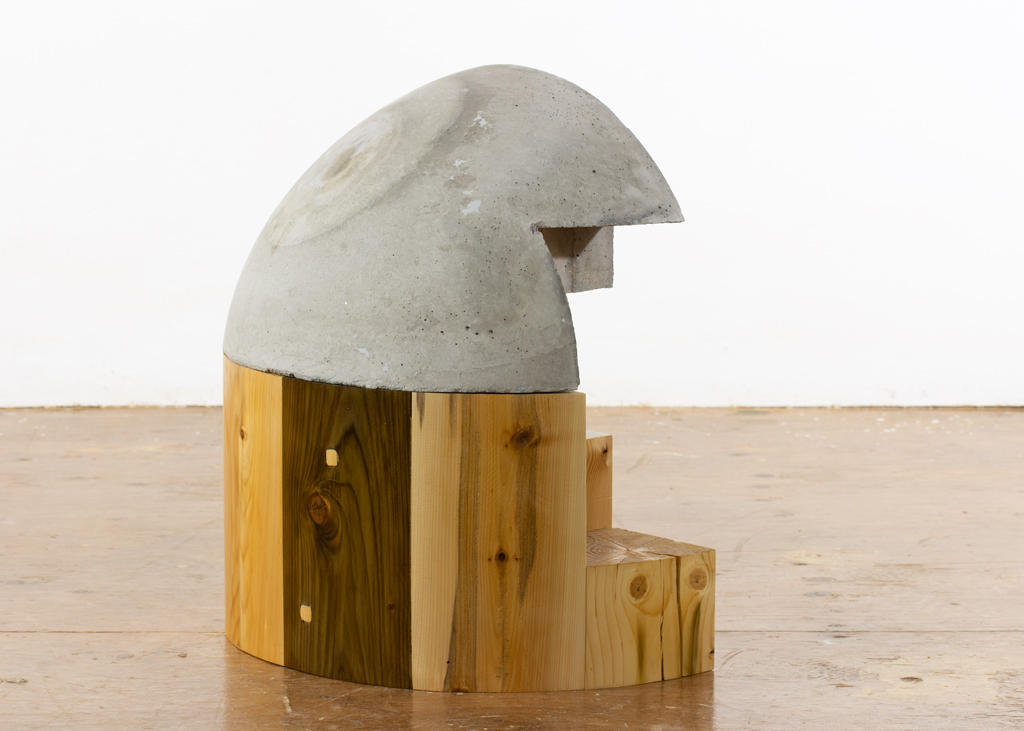 Sculpture de bois et de béton ayant la forme d'un dôme.