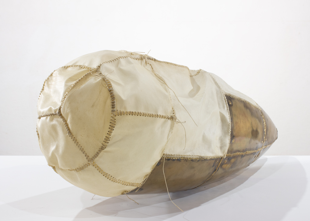 Sculpture faite de laiton chaudronné et de babiche de chèvre. Les points de suture de la babiche sont en continuité avec les cordons de soudure sur le laiton. Curieusement, les deux matériaux sont aussi cousus ensemble. 