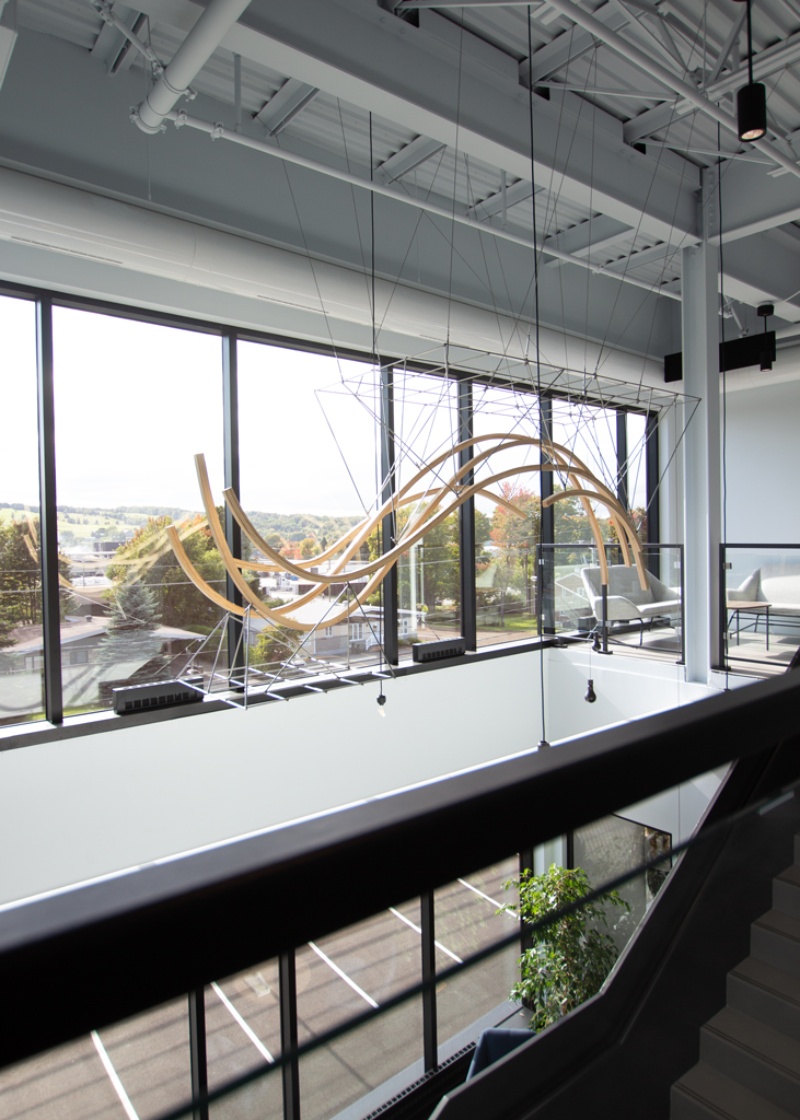 Espace géographique, œuvre suspendue de l'artiste François Mathieu à la MRC de Nouvelle-Beauce. Elle est faite de bois, de bronze et d'acier inoxydable.