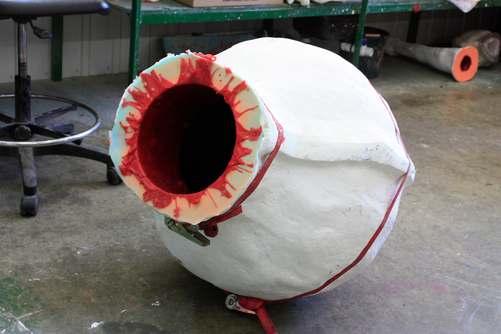 Une cire de fonderie vient d'être coulée dans un moule. Ce moule flexible fait de silicone est parfaitement enchâssé dans une chape de plâtre, laquelle se démonte en deux parties.