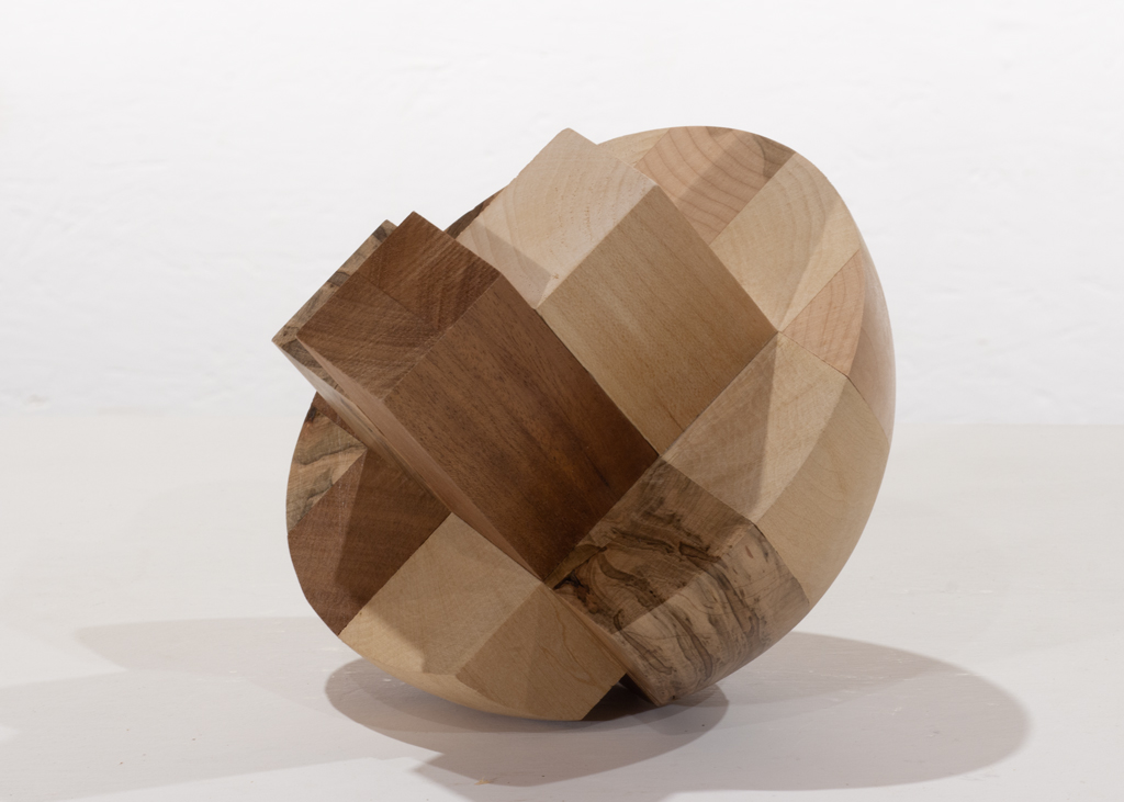 Sculpture de forme hémisphérique, composée de plusieurs essences de bois alternées.