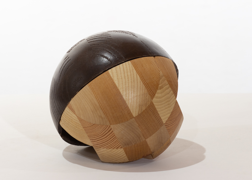 Sculpture sphérique composée partiellement de bois sculpté et de bronze.