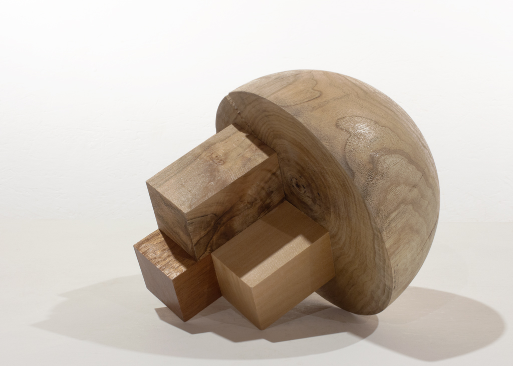 Sculpture partiellement ronde, composée de plusieurs essences de bois.