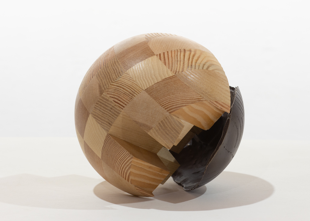 Sculpture ronde composée de bois aux essences alternées puis de bronze.