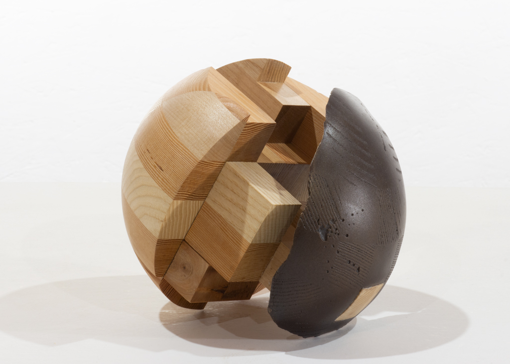 Sculpture ronde composée de bois aux essences alternées puis de bronze.