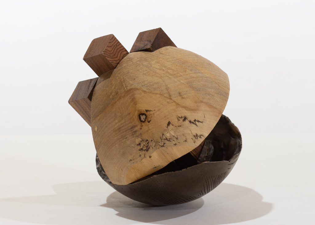 Sculpture ronde faite de bronze et de bois aux essences variées.