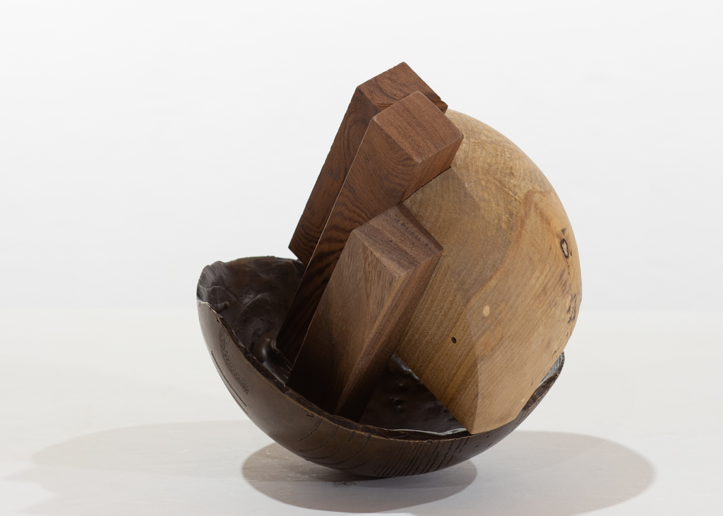 Sculpture ronde faite de bronze et de bois aux essences variées.