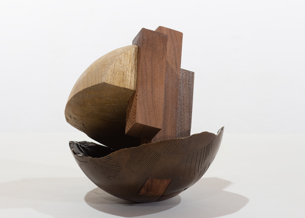 Sculpture ronde faite de bronze et de bois aux essences variées.