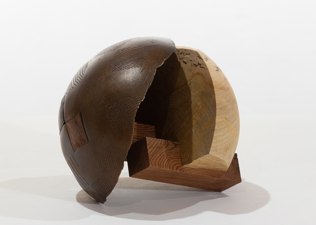 Sculpture ronde faite de bronze et de bois aux essences variées.