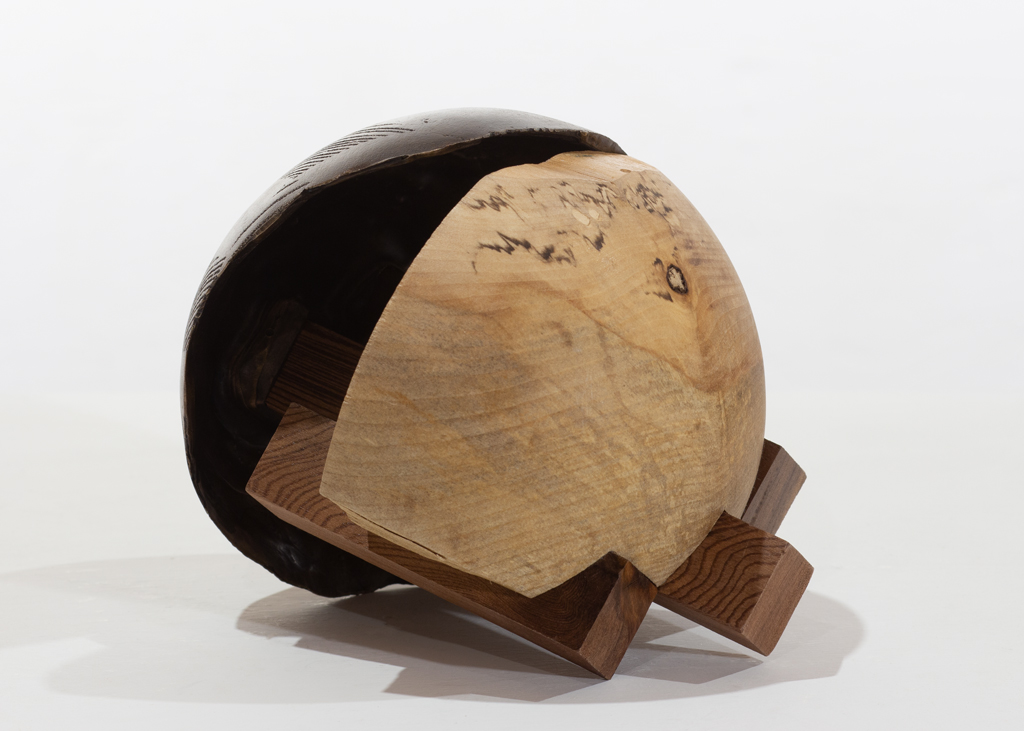 Sculpture ronde faite de bronze et de bois aux essences variées.