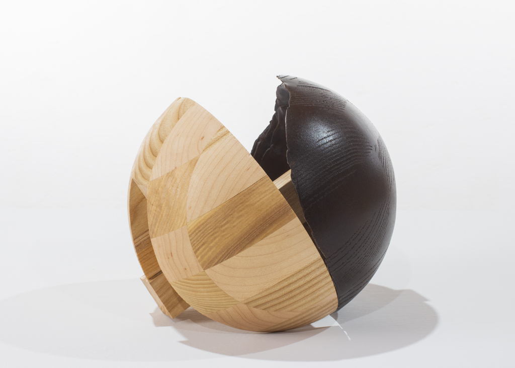 Sculpture ronde faite de bronze et de bois aux essences variées.