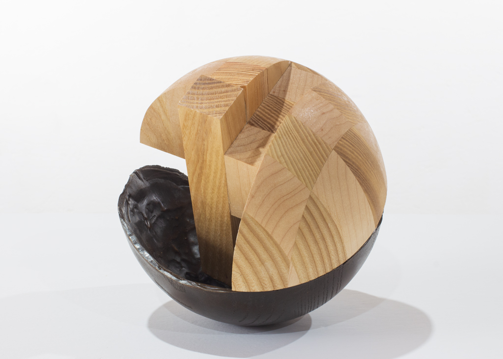 Sculpture ronde faite de bronze et de bois aux essences variées.