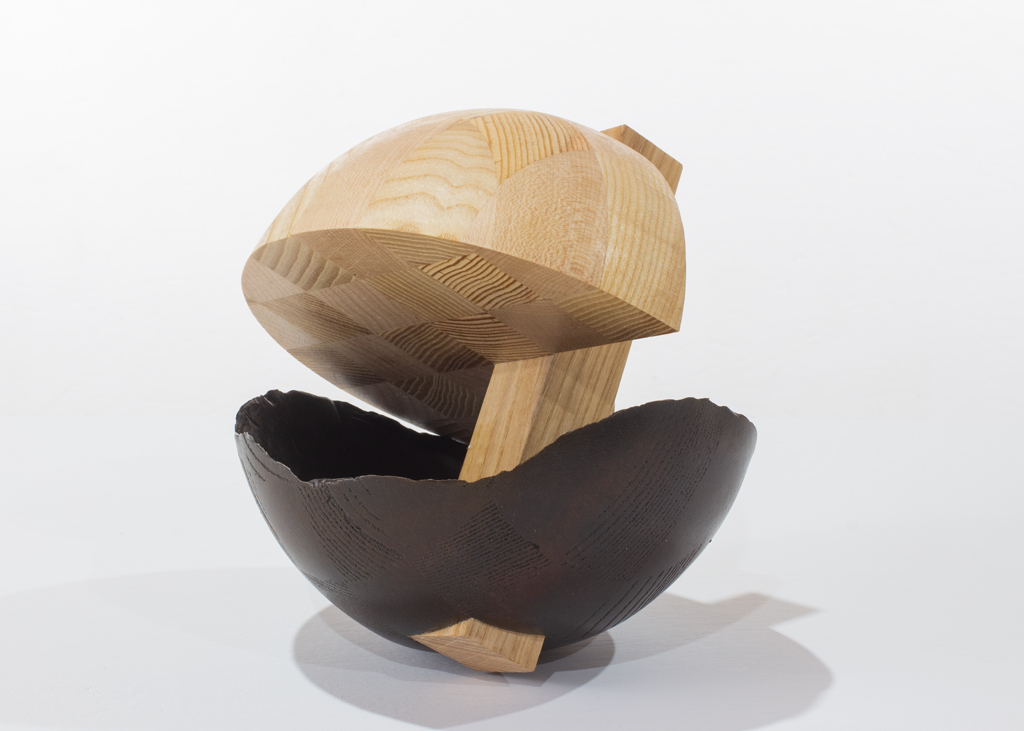 Sculpture ronde faite de bronze et de bois aux essences variées.