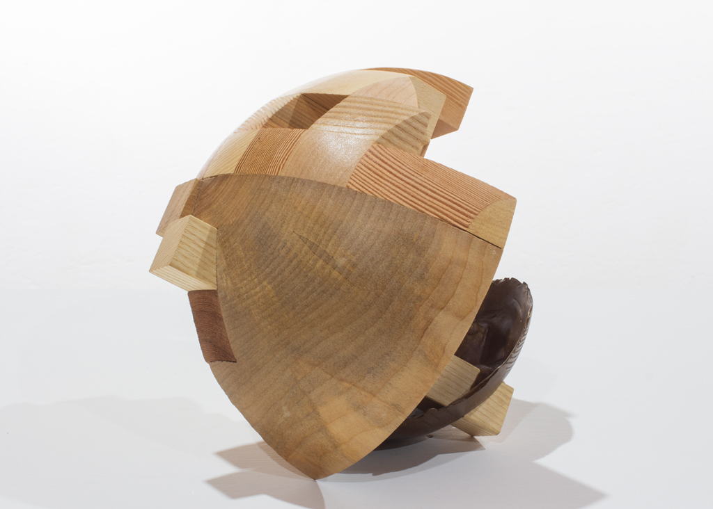 Sculpture ronde faite de bronze et de bois aux essences variées.