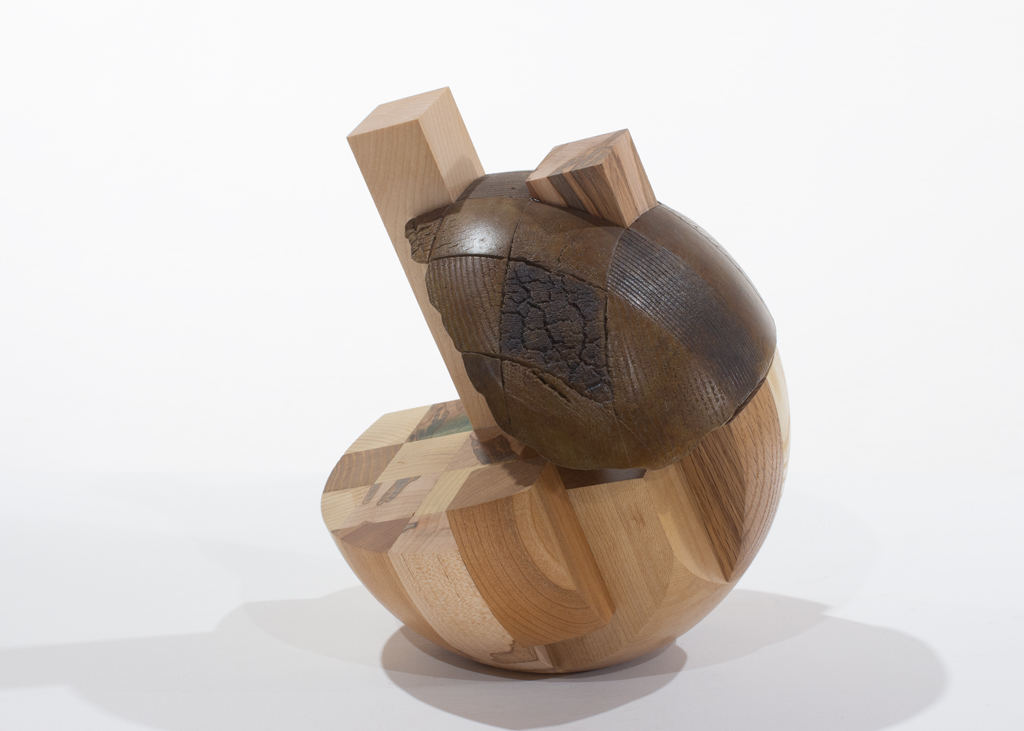 Sculpture ronde faite d'assemblages de bois de diverses essences et de bronze