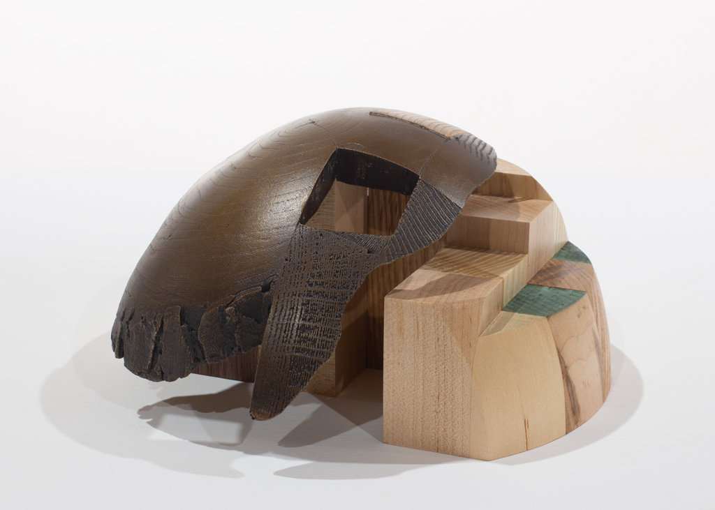 Sculpture ayant la forme d'un dôme. Elle est faite d'assemblages d'essences diverses de bois et de bronze.