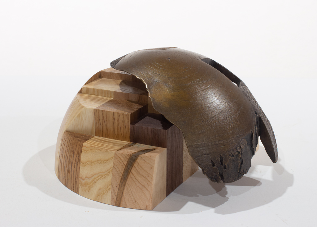 Sculpture ayant la forme d'un dôme. Elle est faite d'assemblages d'essences diverses de bois et de bronze.