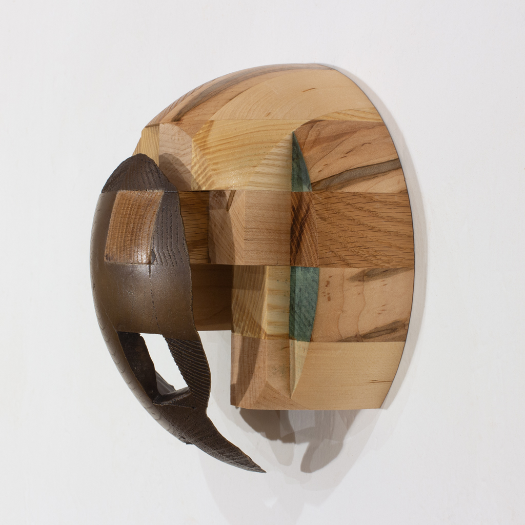 Sculpture murale ayant la forme d'un dôme. Elle est faite d'assemblages d'essences diverses de bois et de bronze.