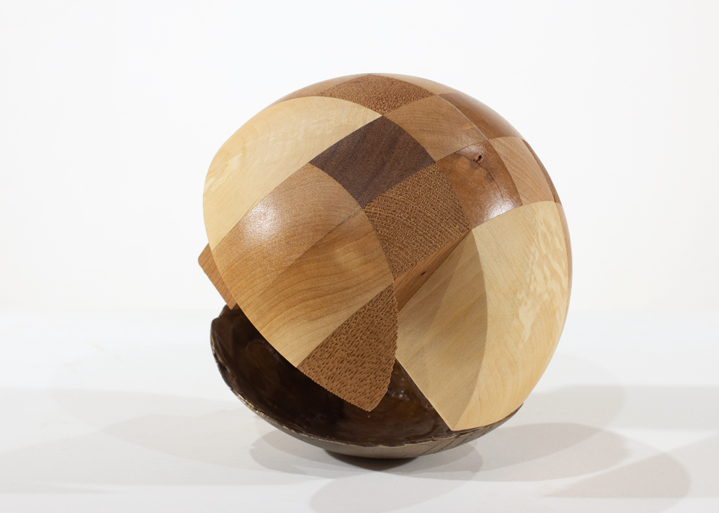 Sculpture ronde faite d'assemblages de bois de diverses essences et de bronze