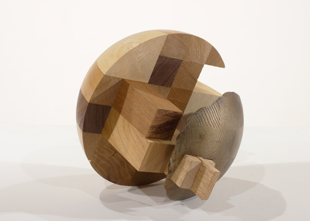 Sculpture ronde faite d'assemblages de bois de diverses essences et de bronze