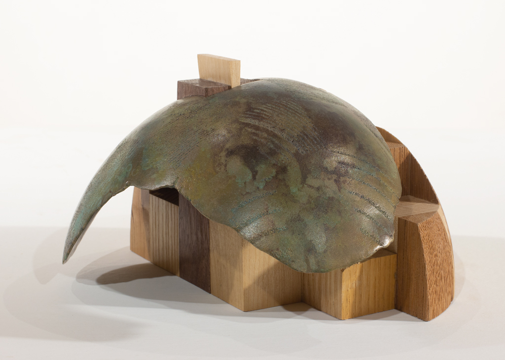 Sculpture ayant la forme d'un dôme. Elle est faite d'assemblages d'essences diverses de bois et de bronze.