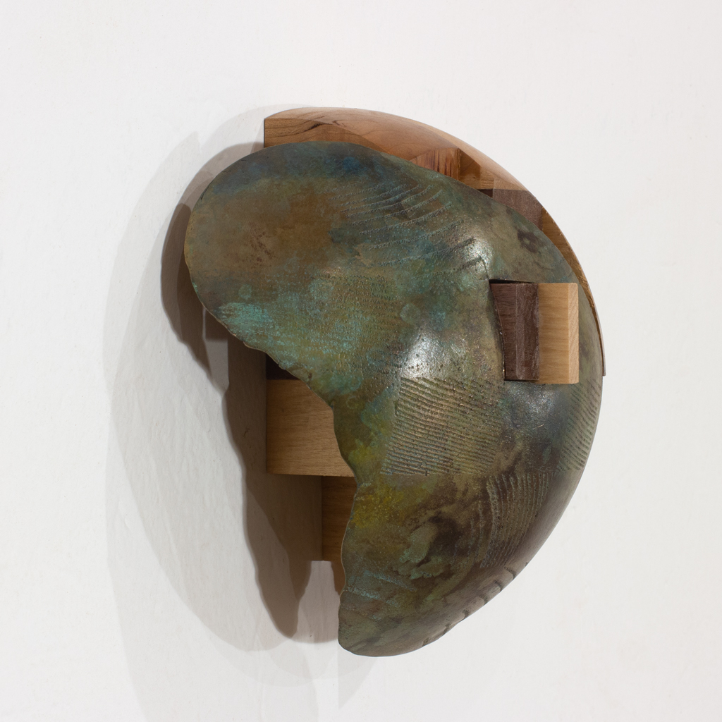 Sculpture murale ayant la forme d'un dôme. Elle est faite d'assemblages d'essences diverses de bois et de bronze.