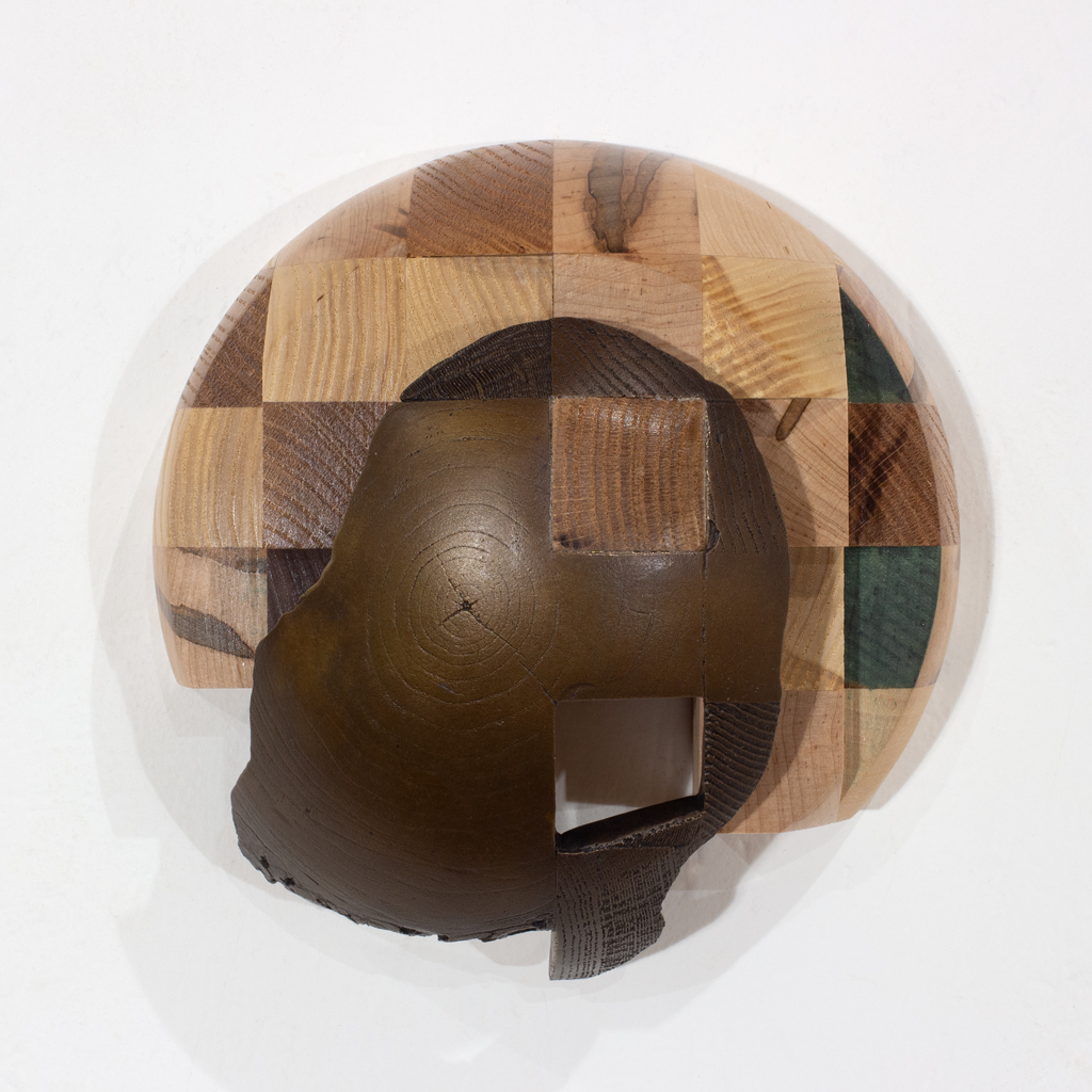 Sculpture murale ayant la forme d'un dôme. Elle est faite d'assemblages d'essences diverses de bois et de bronze.