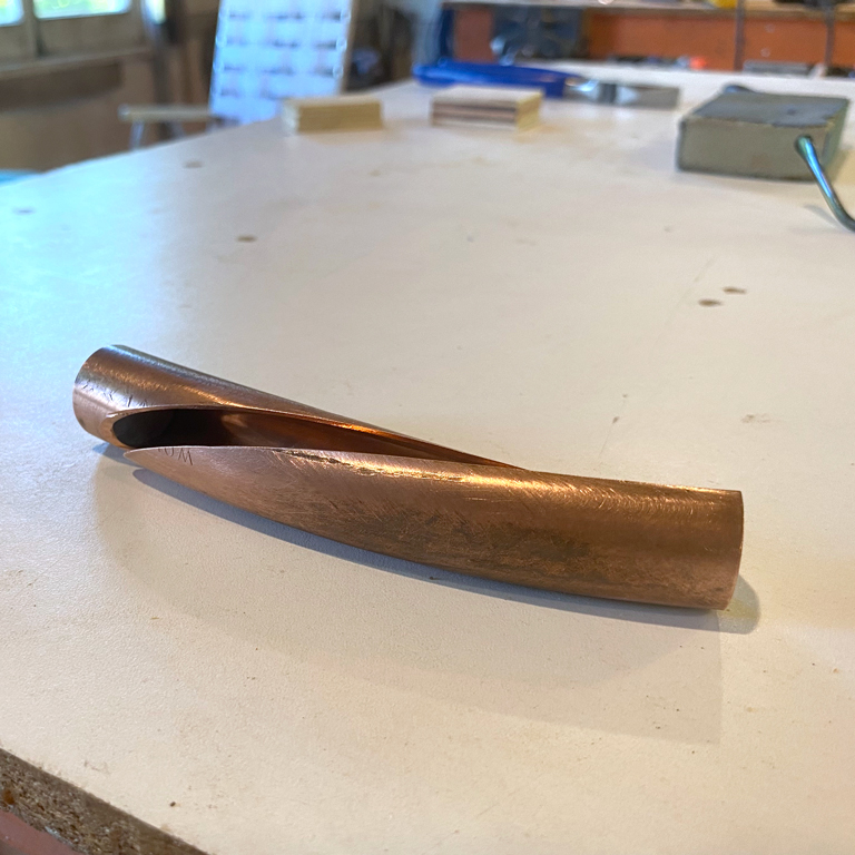 Bout de tuyau courbé et refendu, ayant servi à expérimenter une forme simple pouvant devenir sculpture.