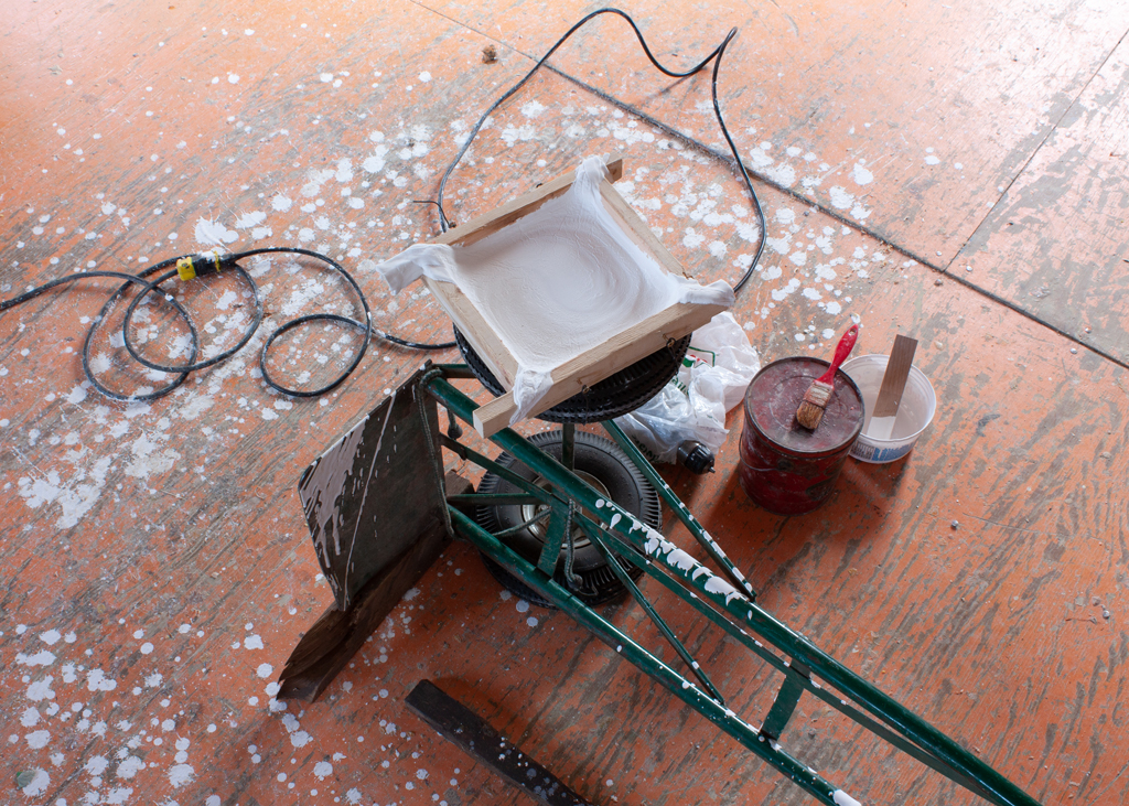 Dispositif servant à faire tourner un moule carré rempli de plâtre liquide.