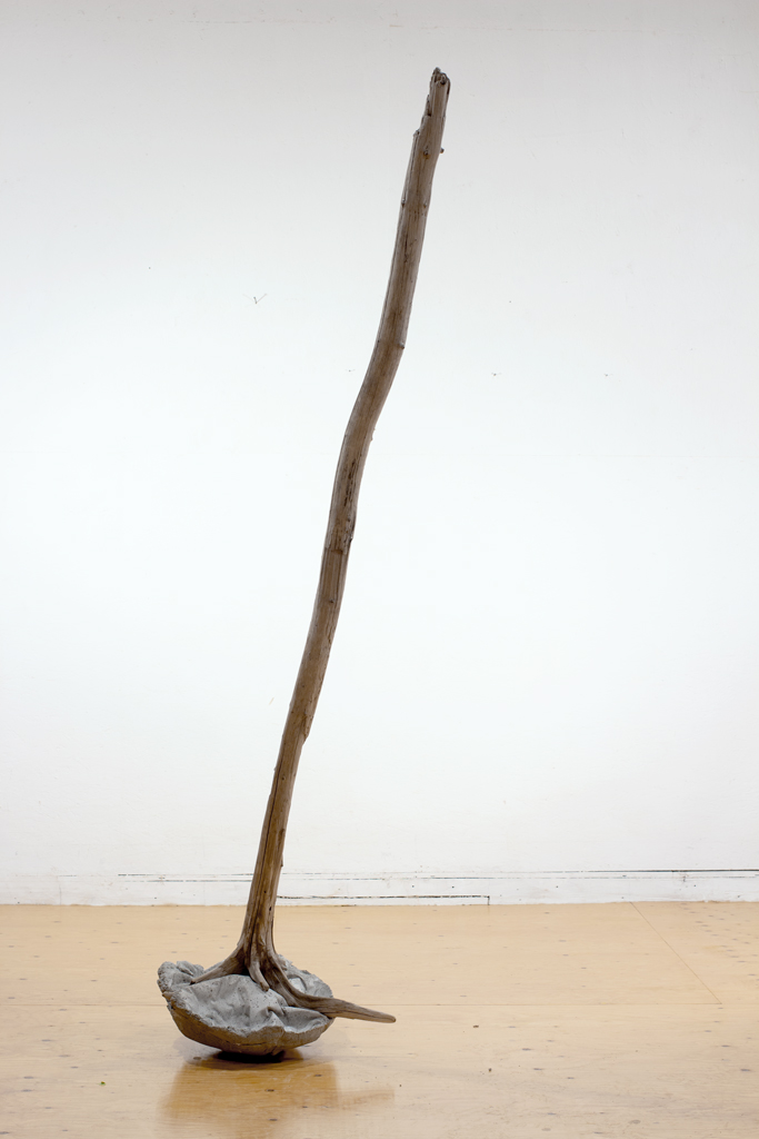 Sculpture - Long bois de grève s'insérant dans une base de béton.