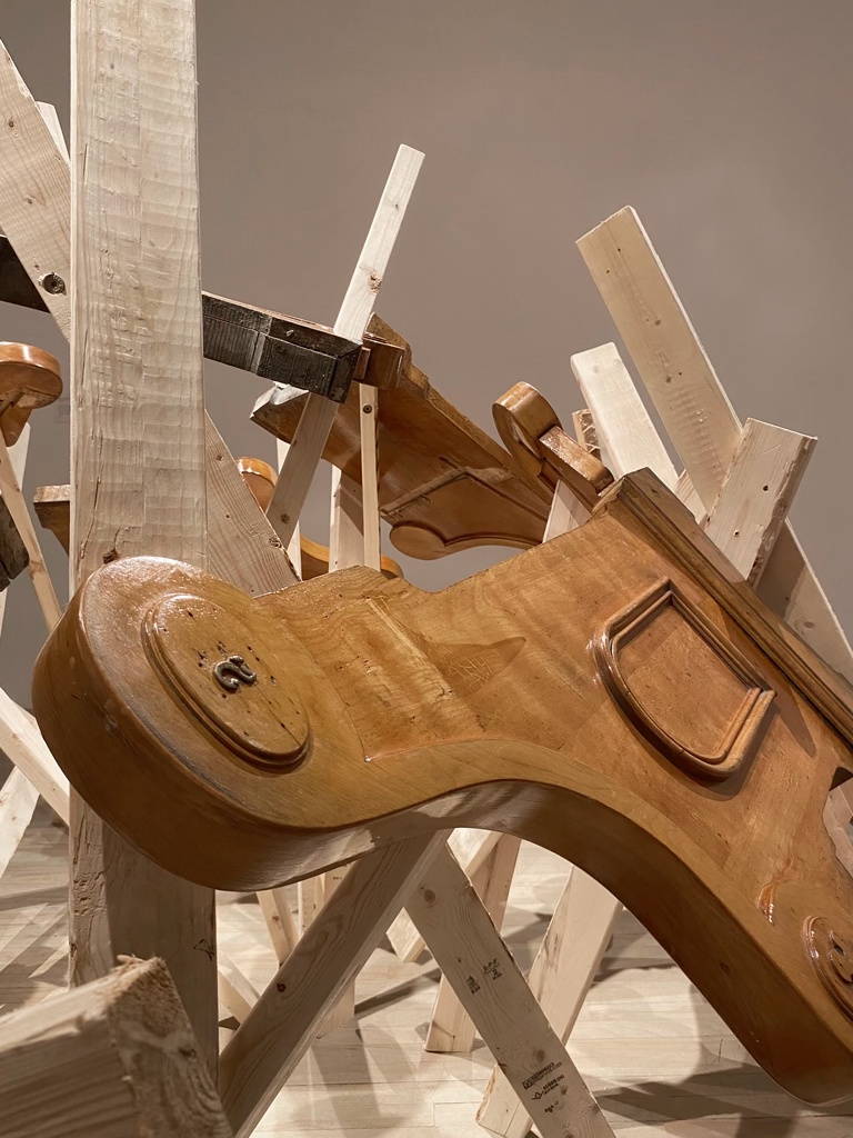 Détail d'une sculpture prenant la forme d'un dôme, faite d'un assemblage de bancs d'église et de 2x4 d'épinette.