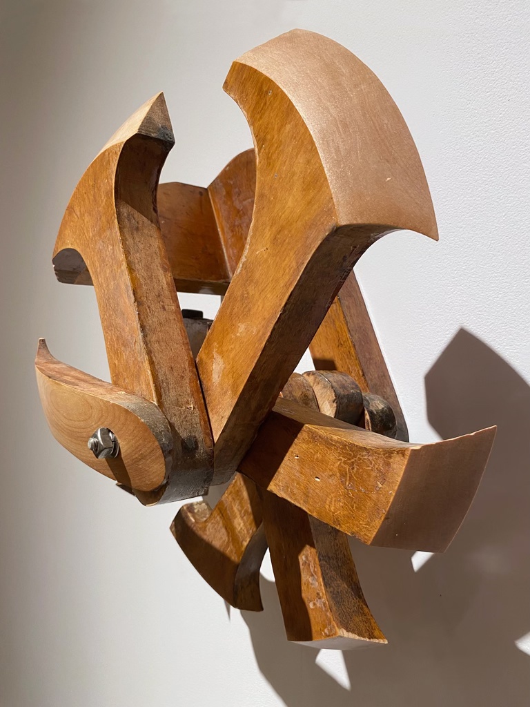 Sculpture murale faite d'un assemblage d'agenouilloirs d'église, leswuels ont été sculptés sous la forme d'une demi-sphère.