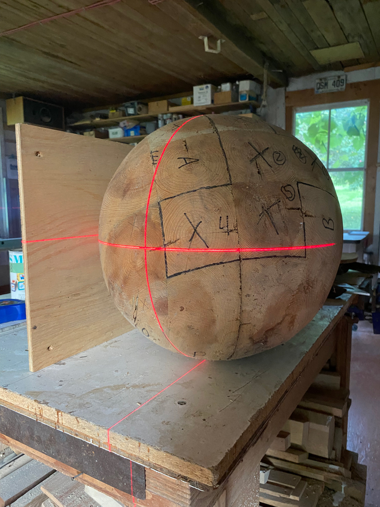 La sphère de bois est tracée à l'aide d'un laser, dans le but d'en retirer un quartier.